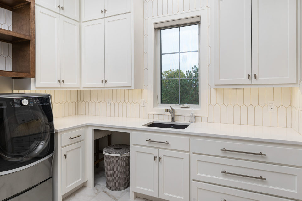 Laundry room with white quartz countertops and tiles