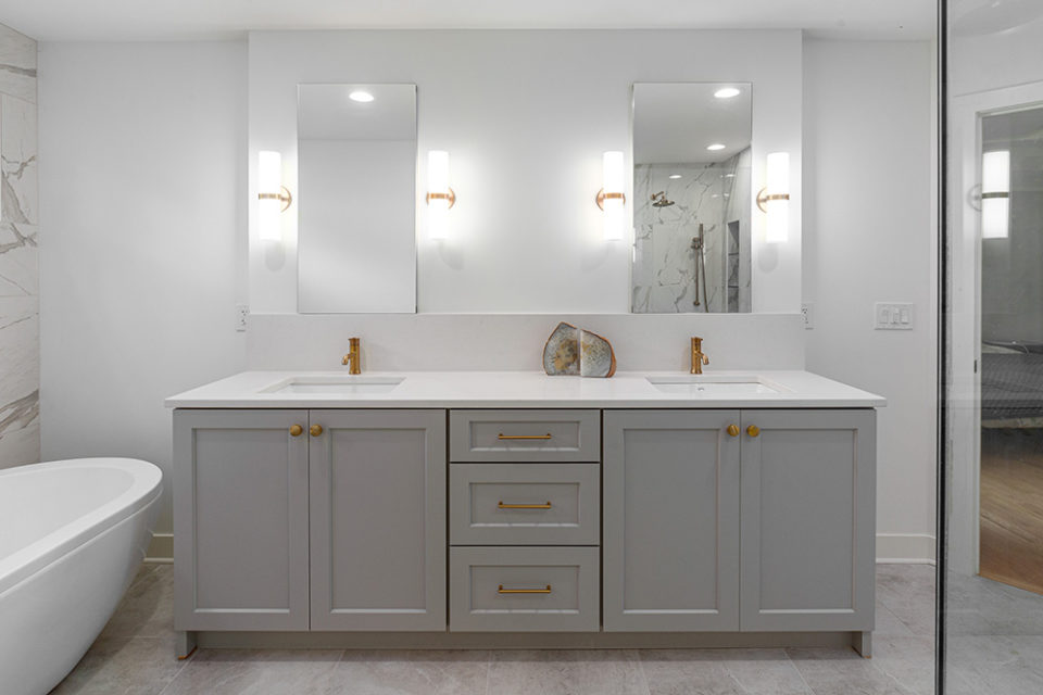 bathroom with white stone his and her vanity and gray cabinets